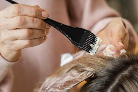 femeie la salon care isi vopseste parul