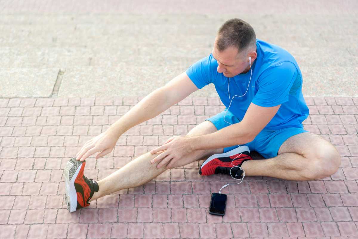 Prevenirea carceilor - exercitii si modificari de stil de viata_Barbat facand exercitii de intindere in aer liber